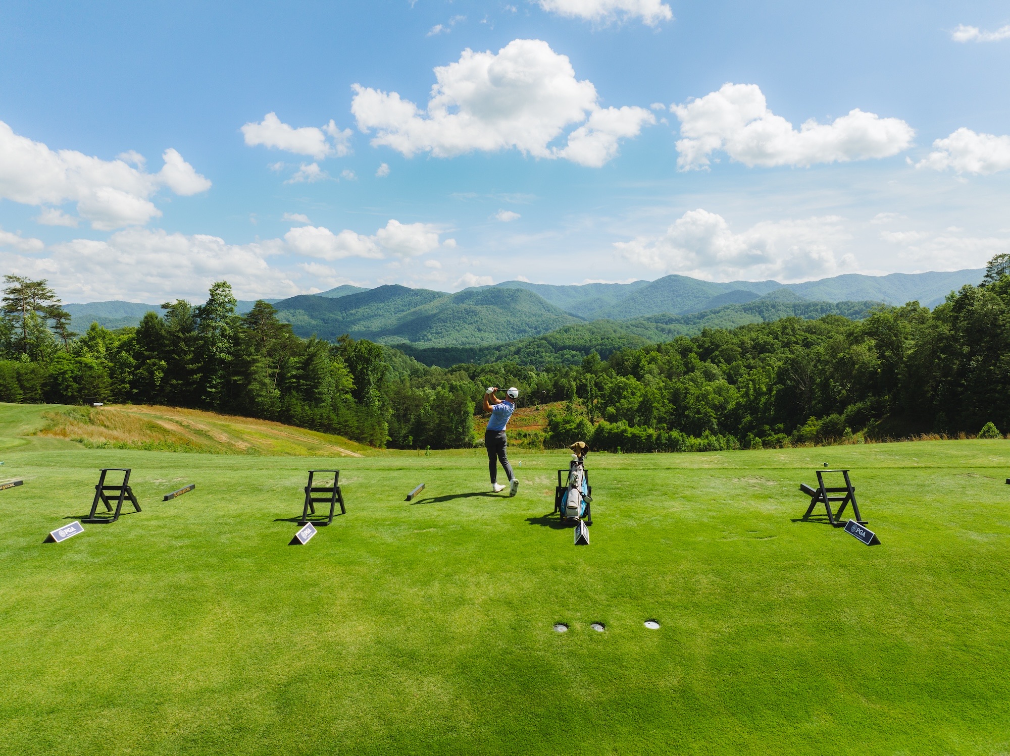 Golfer on the Sequoyah National range beneath mountain ridges