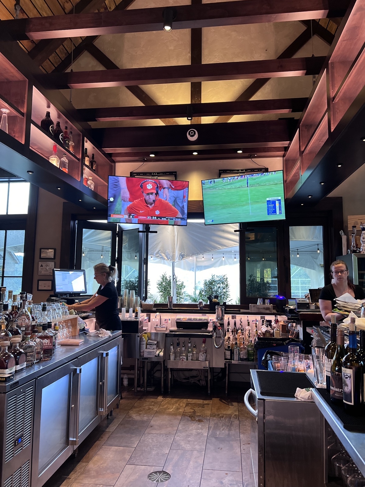 Clubhouse bar with football and golf broadcasts on screen